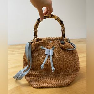 on-trend woven handbag/cross body with light blue accents + faux bamboo handle